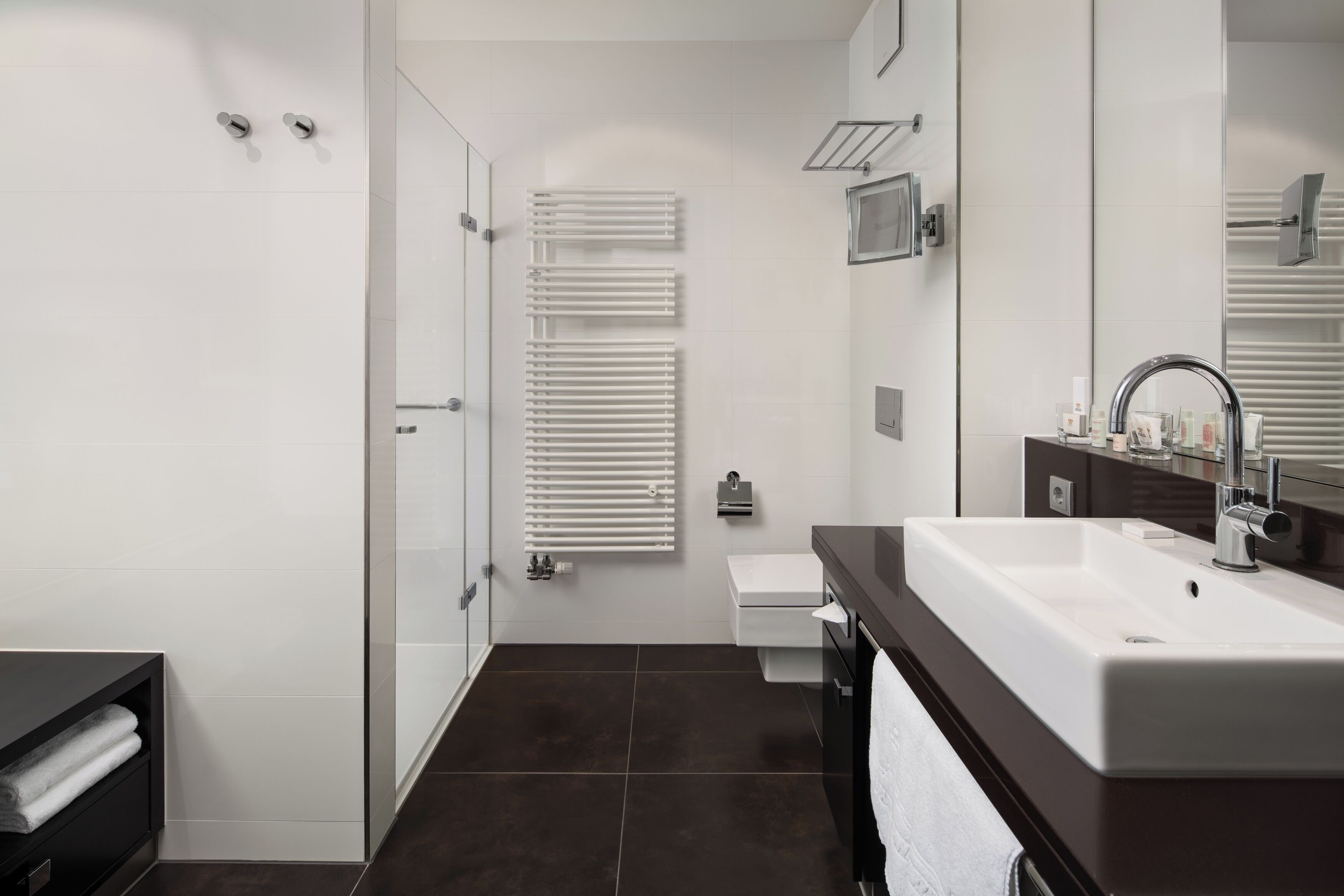 A modern bathroom with a shower, toilet, and sink.