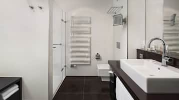 A modern bathroom with a shower, toilet, and sink.