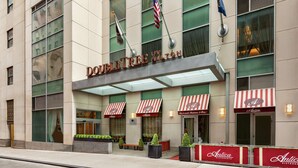 The exterior of Doubleday Hilton with a modern facade, large windows, and red and white striped awnings. - DoubleTree by Hilton New York Downtown (New York)