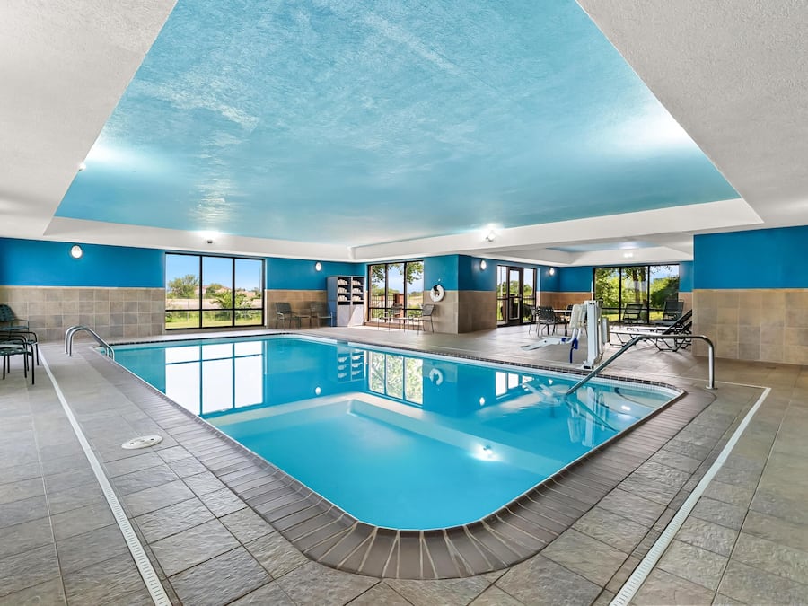 Ein Innenpool mit klaren Glaswänden, einem gefliesten Boden und einer blau gestrichenen Decke.