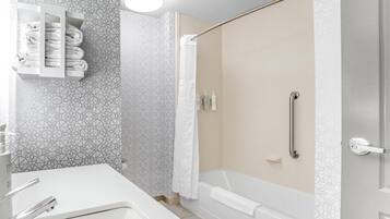 A modern bathroom with a shower, a toilet, and a sink.