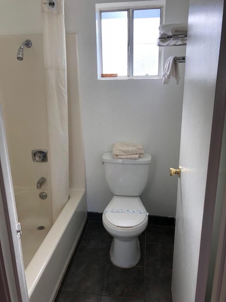 Un baño pequeño con inodoro, ducha y ventana.