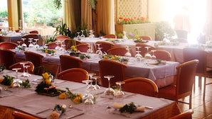A restaurant with multiple tables set for dining, featuring a variety of table settings and chairs. - Rovere (Losone)