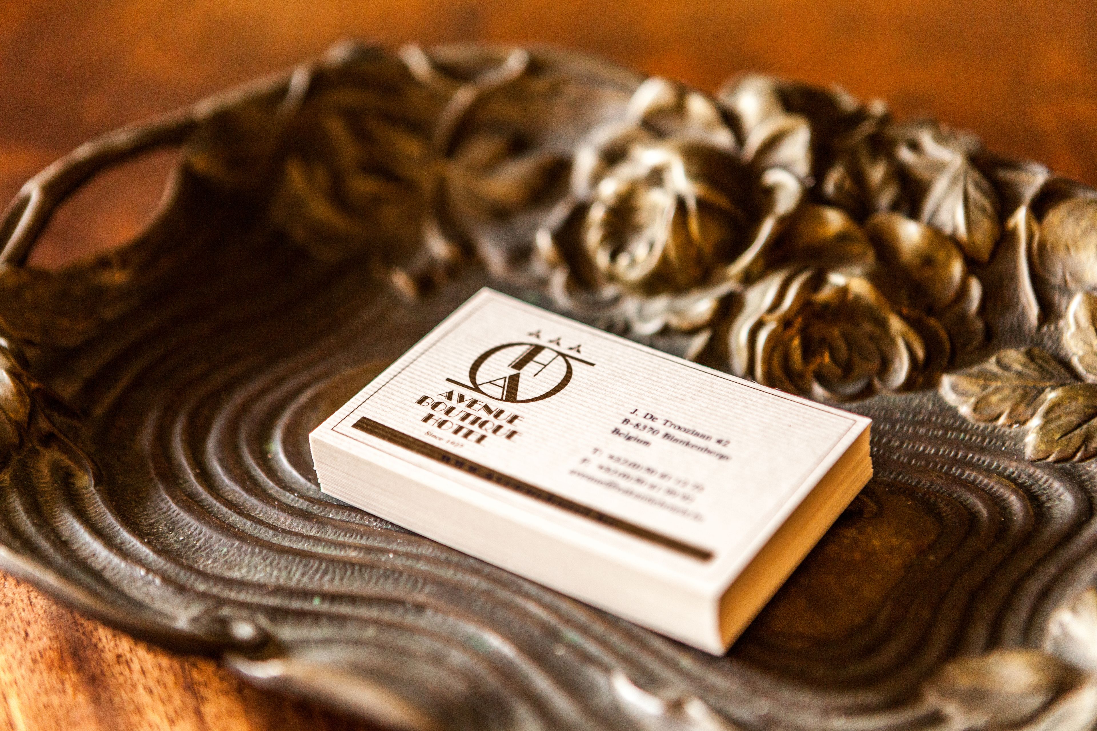 A business card on an ornate metal tray.