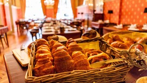 Un buffet proposant une variété de produits de boulangerie, notamment des croissants et des petits pains, disposés sur des tables.