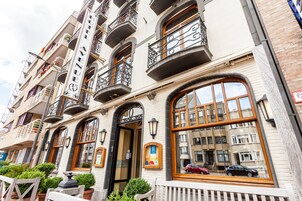 Un immeuble à plusieurs étages doté de balcons, de grandes fenêtres et d’une entrée bien visible.
