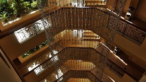 Un atrium à plusieurs niveaux, doté d’un escalier en colimaçon central et de décorations suspendues.