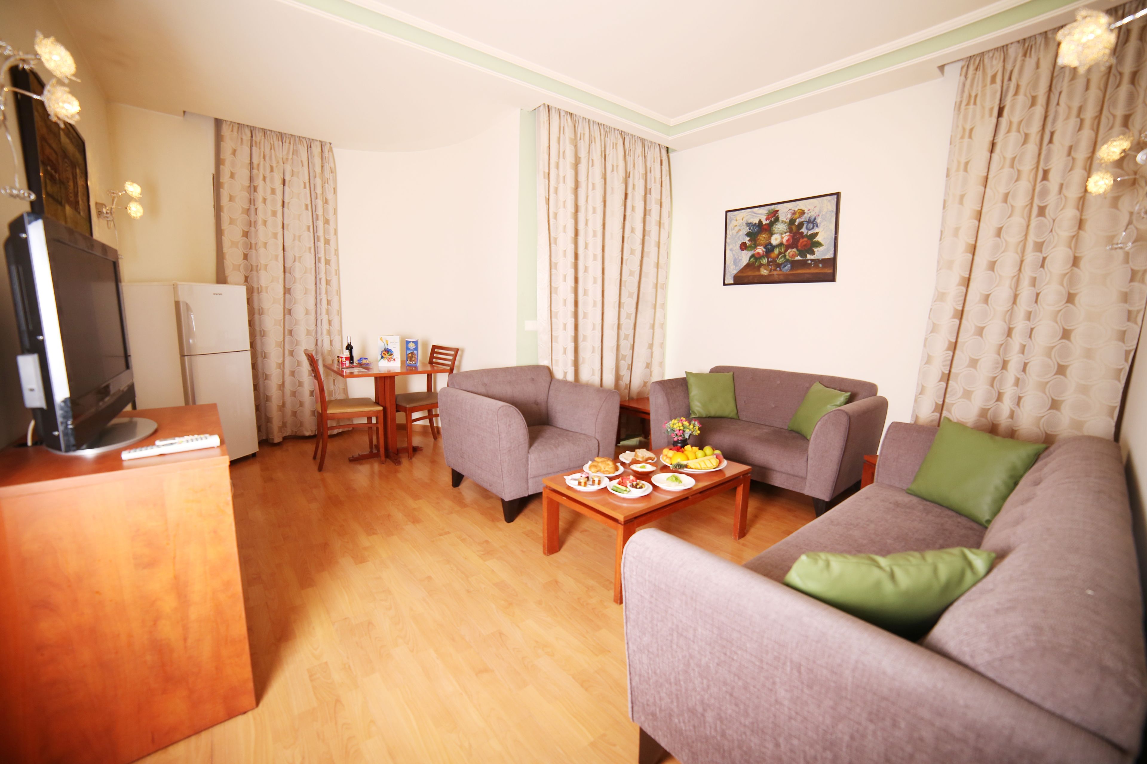 Una sala de estar con sofá, mesa de centro, televisor y un comedor con sillas y mesa.
