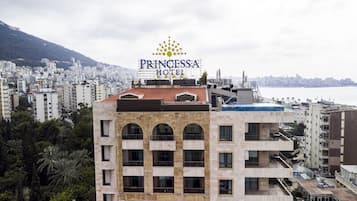 Un hôtel doté d’une piscine sur le toit, de plusieurs balcons et offrant une vue sur le paysage urbain.