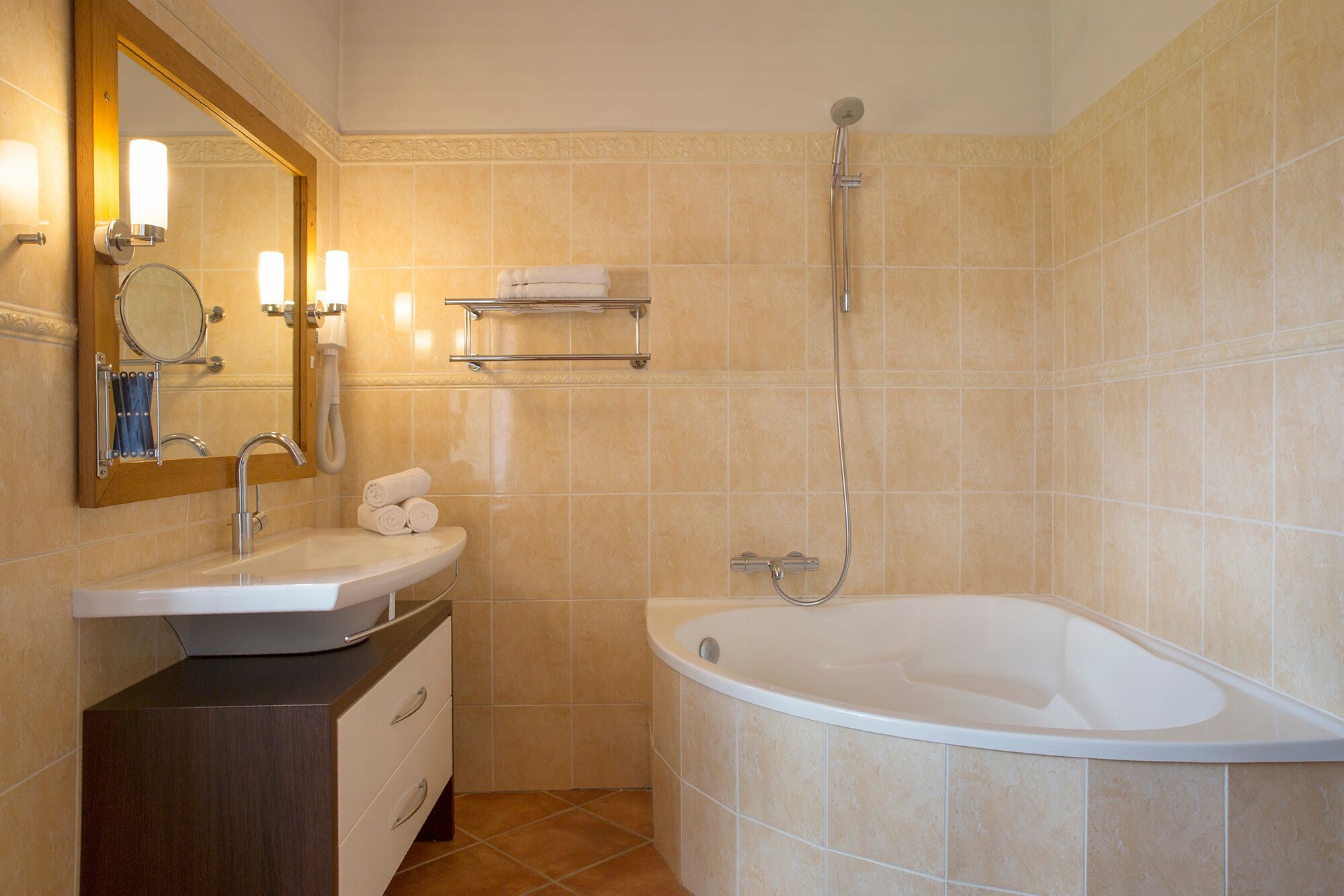 A bathroom with a sink, mirror, towel rack, and a bathtub.