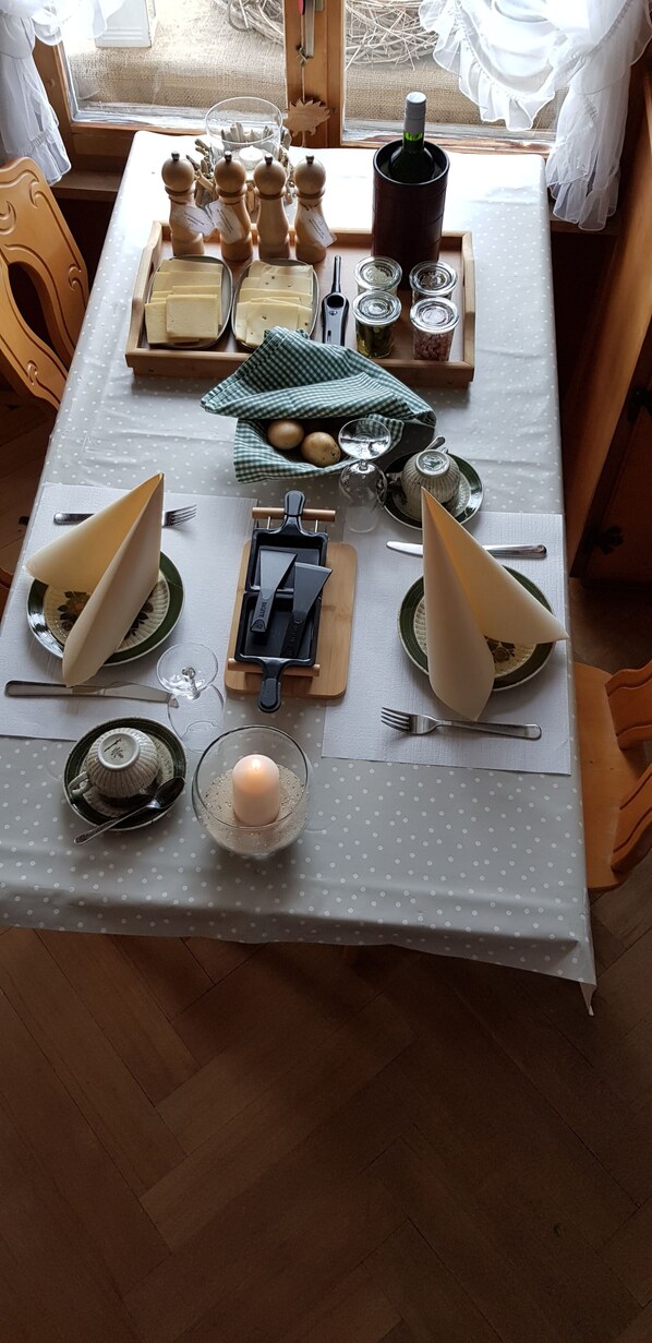 Une table à manger dressée avec différents plats, couverts et objets de décoration.