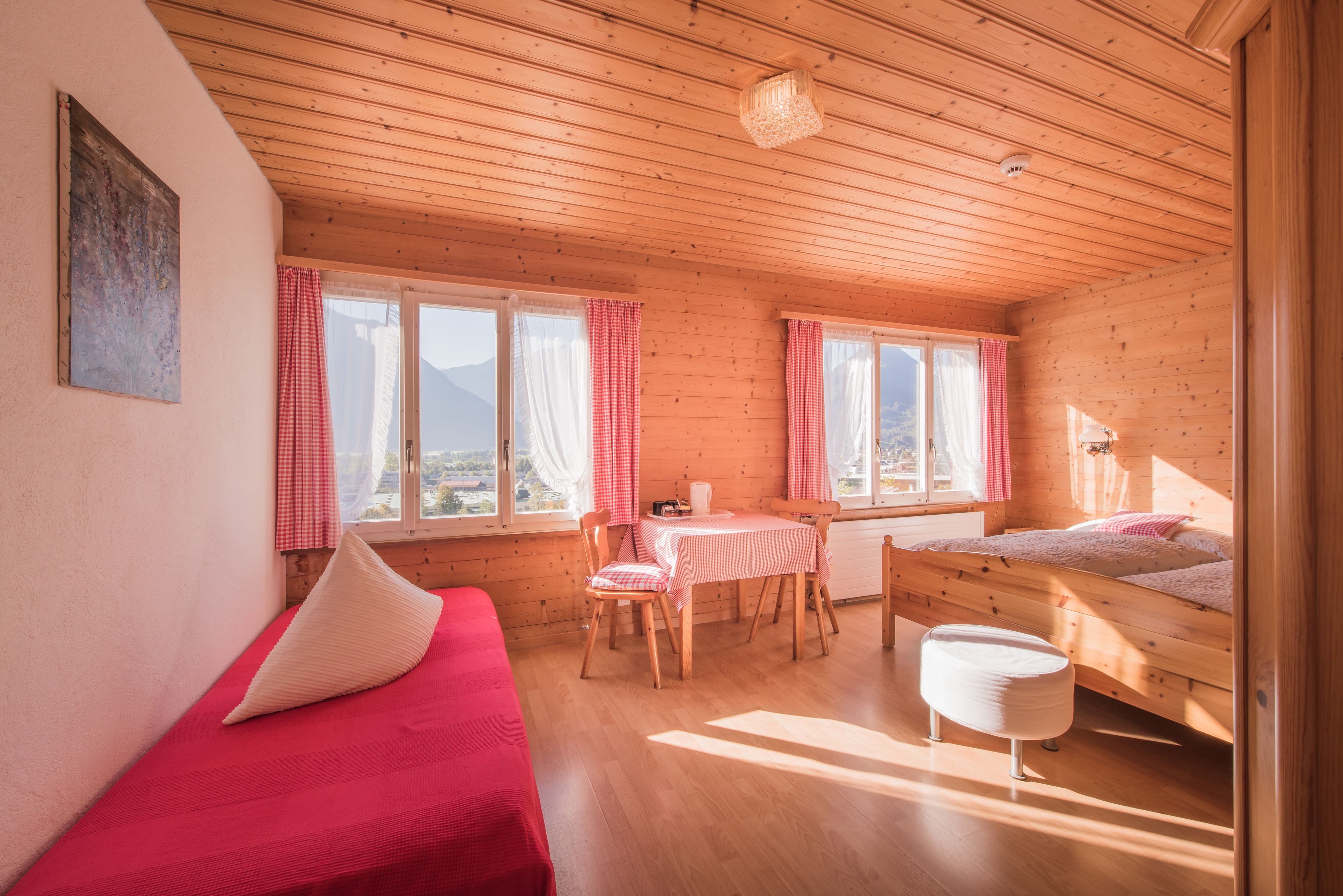 Une cabane confortable avec un intérieur en bois, un coin repas et un lit.