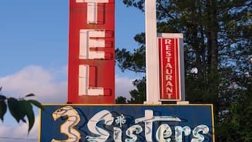 A motel sign with 'Motel' and '3 Sisters' prominently displayed.