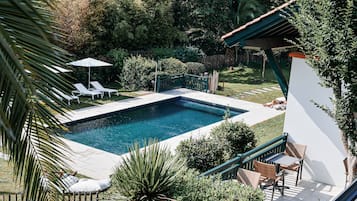 Een seizoensgebonden buitenzwembad en parasols bij het zwembad