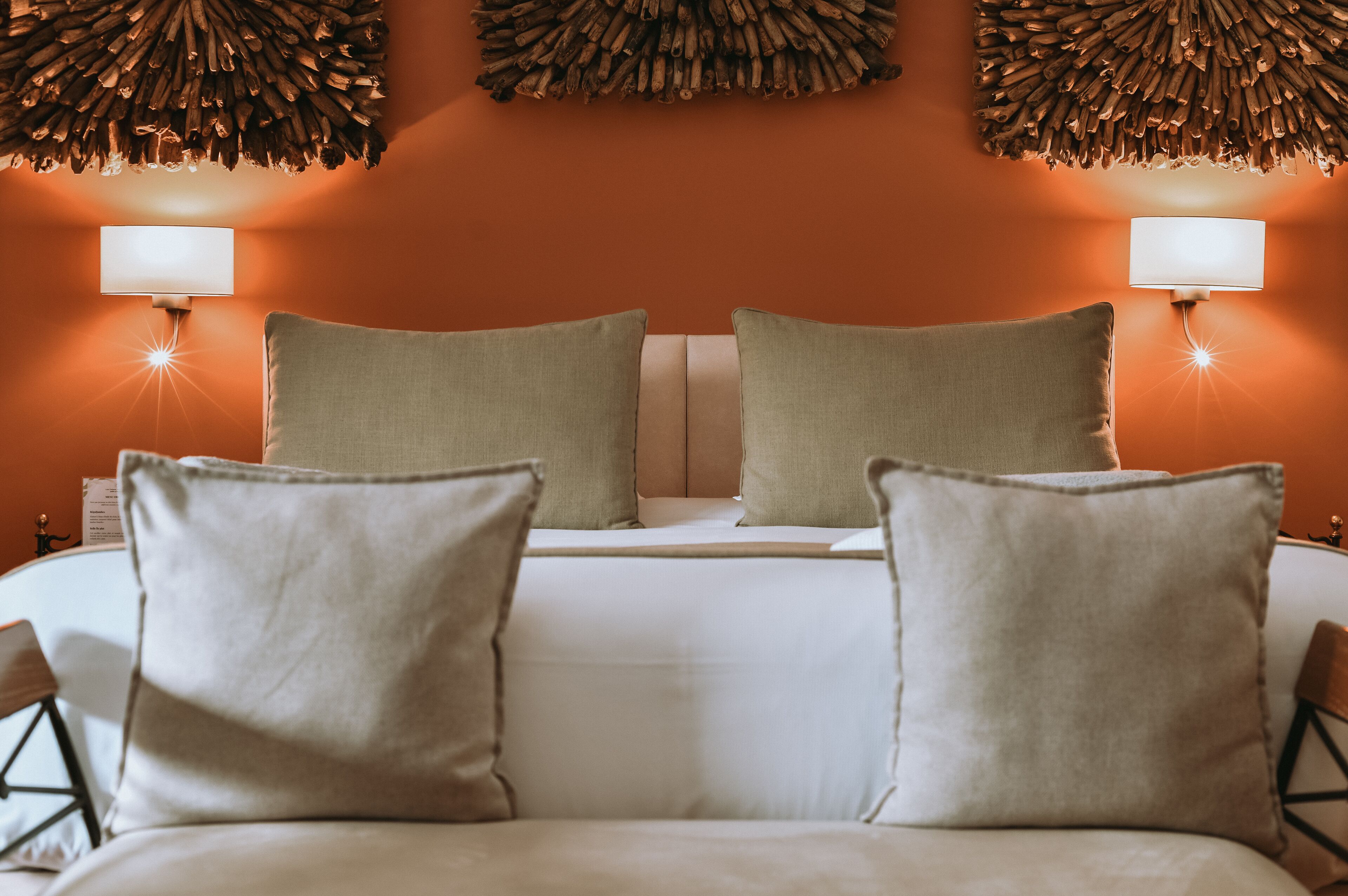 Una habitación de hotel con una cama grande, dos lámparas de noche y un tapiz decorativo.