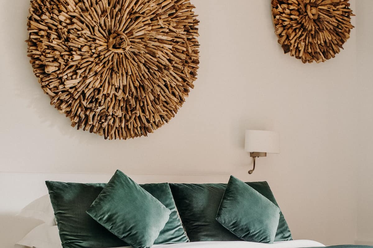 A bedroom with a bed, two round wall decorations, and a bedside lamp.