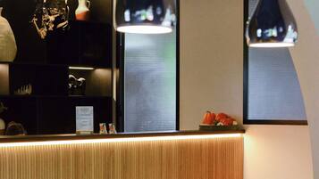 A pool table with balls, a wooden reception desk, and pendant lighting.