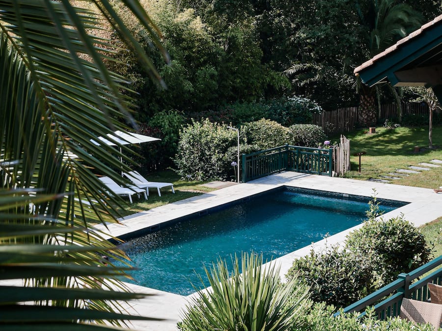 Una piscina al aire libre de temporada, sombrillas
