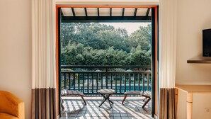 A room with a view of a balcony, a sofa, and a television. - Les Frères Ibarboure (Bidart)