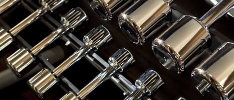 A close-up of metallic, cylindrical objects with reflective surfaces, arranged in a grid pattern.