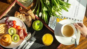 A breakfast tray with toast, fruit, and a cup of coffee.