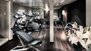 Un gimnàs modern amb diversos equips d'exercici, incloent cintes de córrer i aparells de musculació.