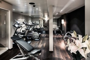 A modern gym with various exercise equipment, including treadmills and weight machines. - Hotel D - Basel - Boutique Hotel (Basel)