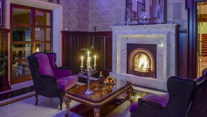 Uma sala de estar luxuosa com lareira, móveis elegantes e um candelabro.