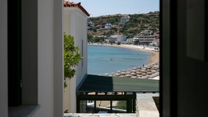 Vista desde un balcón sobre una playa, con edificios al fondo.
