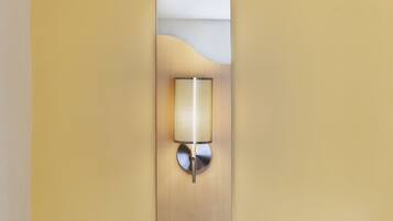 Ein Hotelzimmer mit einem Bett, einer Wandleuchte und einem Holzkopfteil.