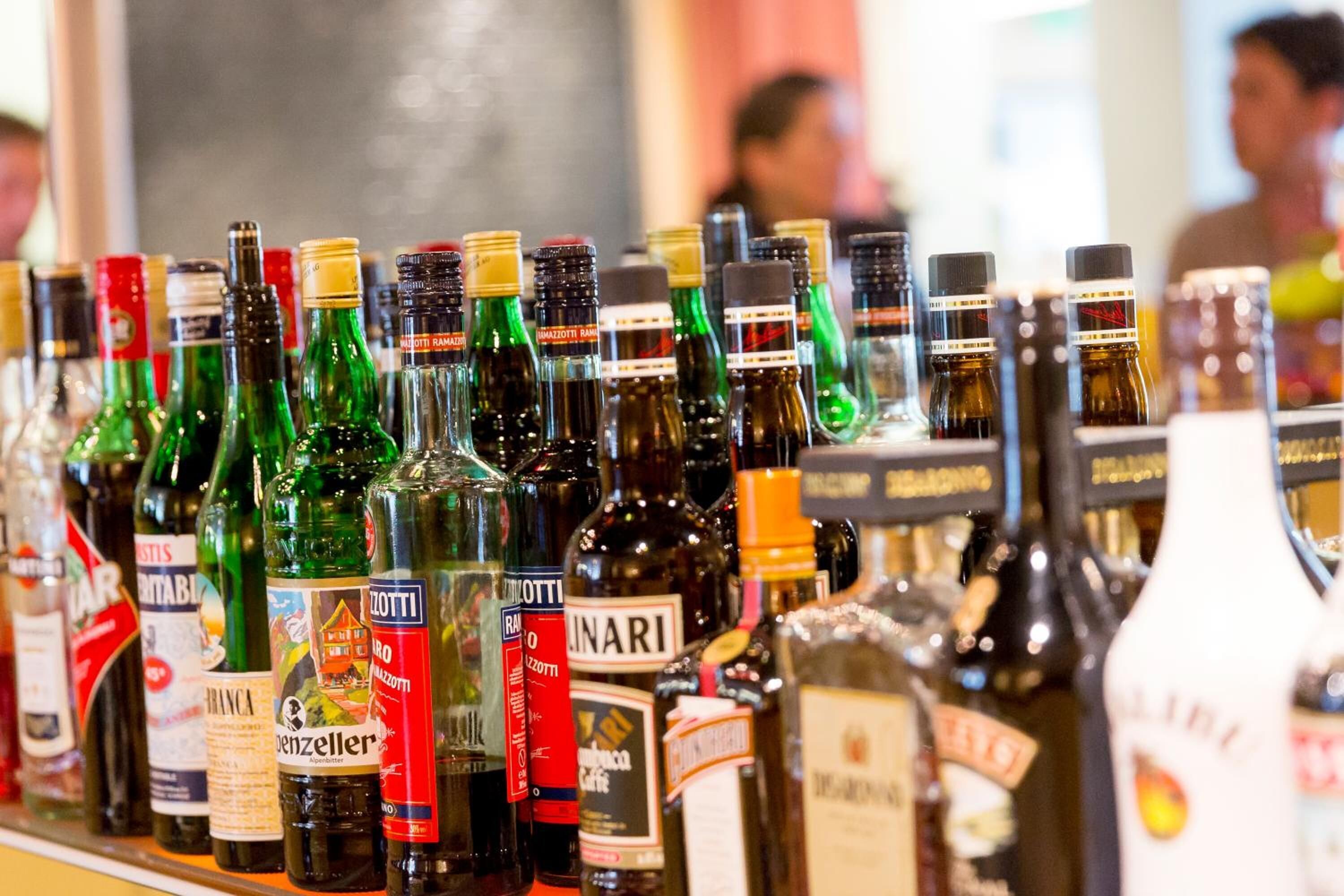 A variety of liquor bottles displayed on a shelf.