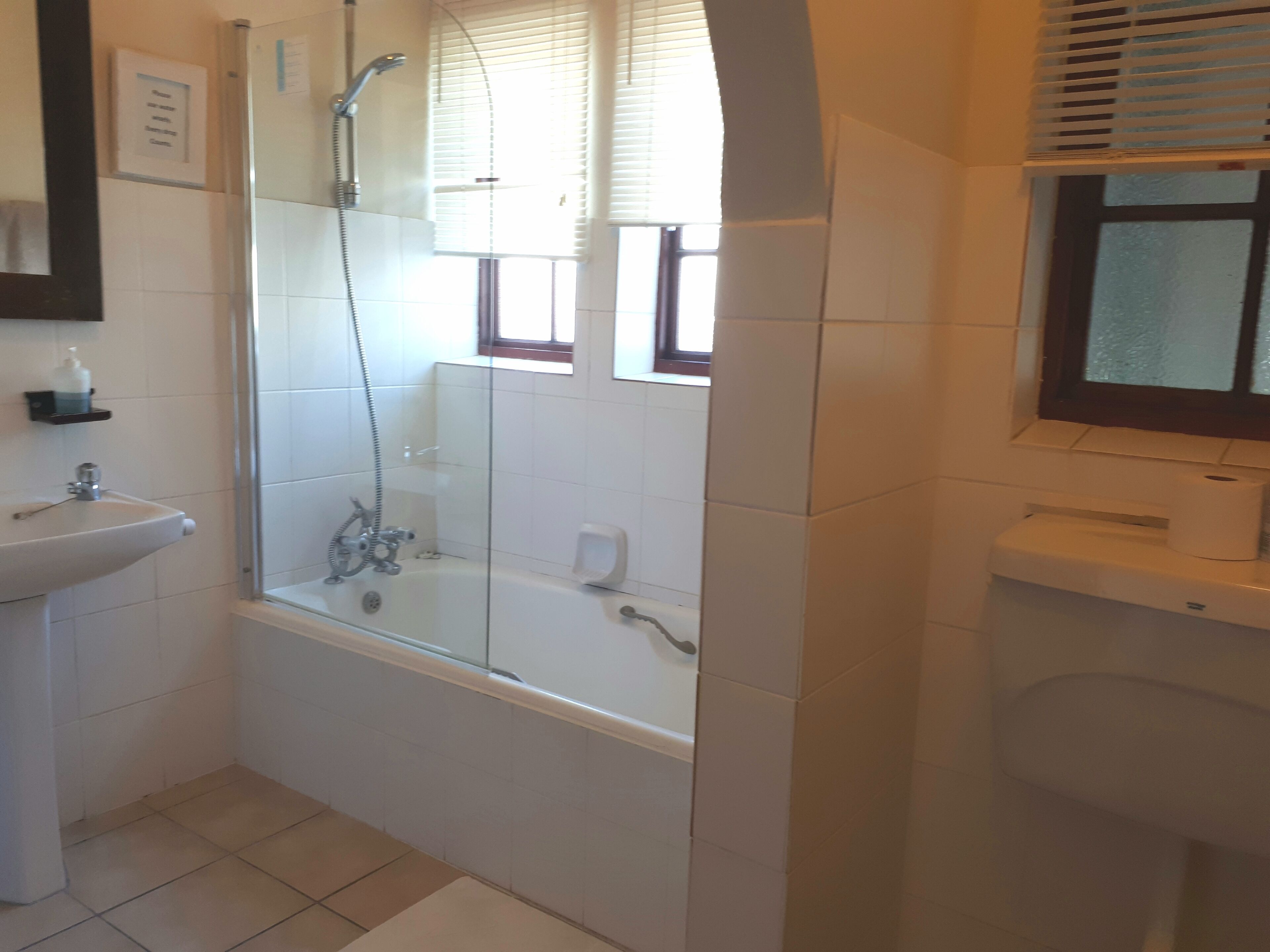 Un baño con ducha, lavabo e inodoro.