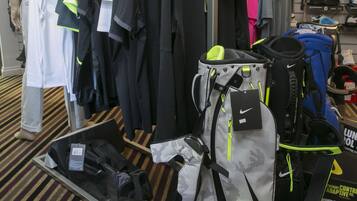 A Nike Lunar Control 3 shoe display with various athletic wear and accessories.