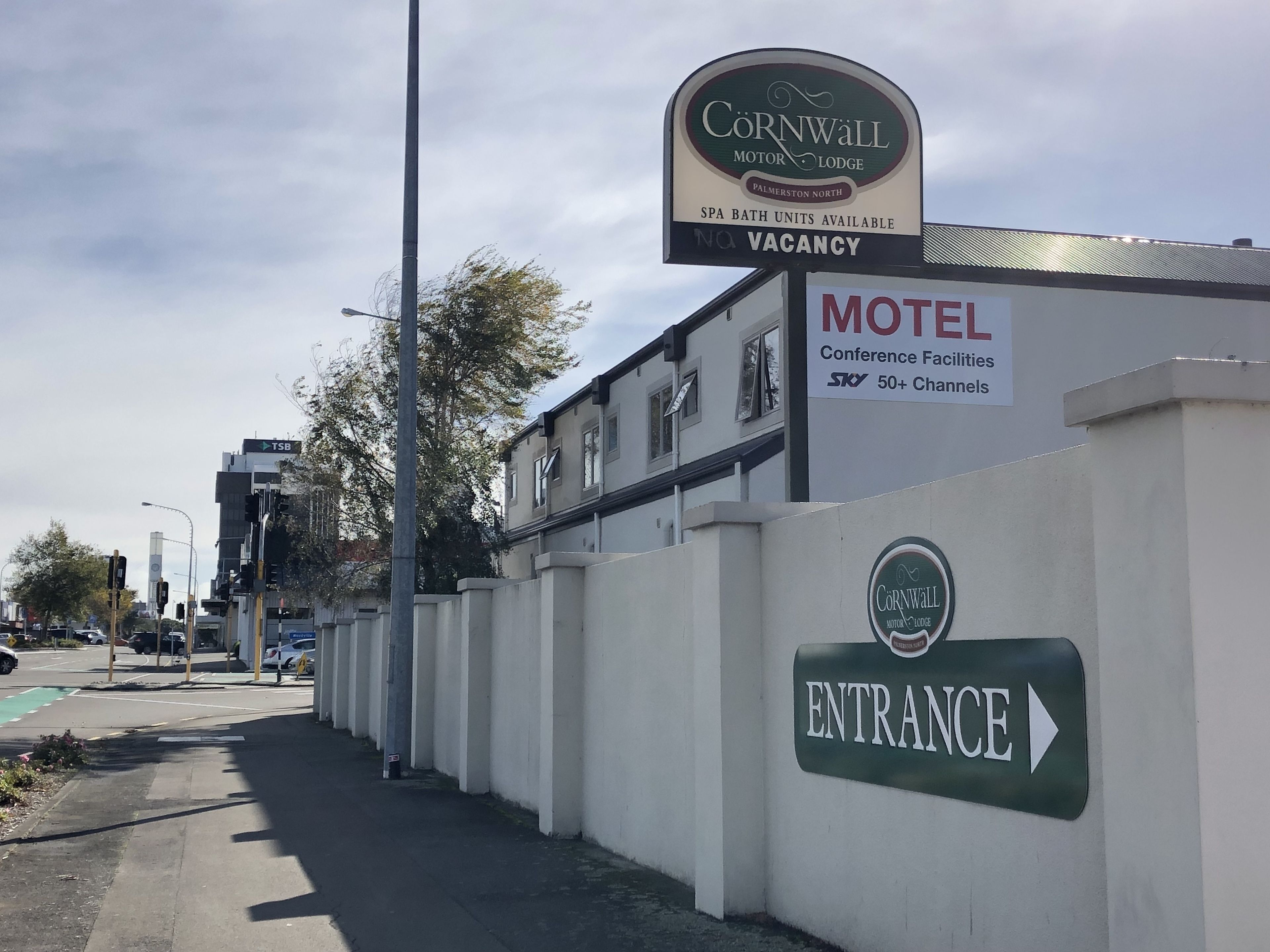 A motel entrance with a sign indicating 'Cornwall Motor Lodge' and 'SPA Bath Units Available'.