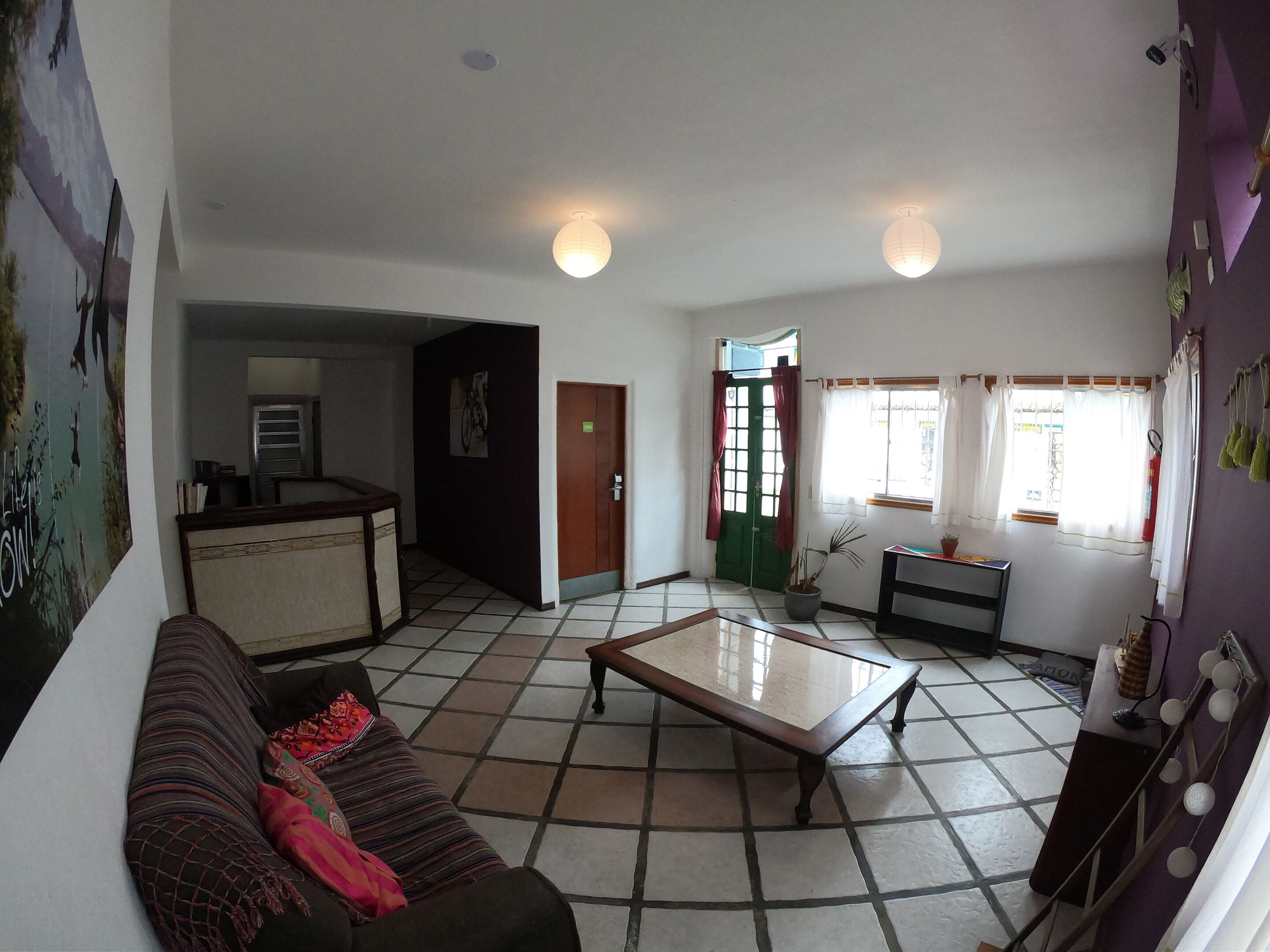 A living room with a sofa, a coffee table, and a kitchen area in the background.