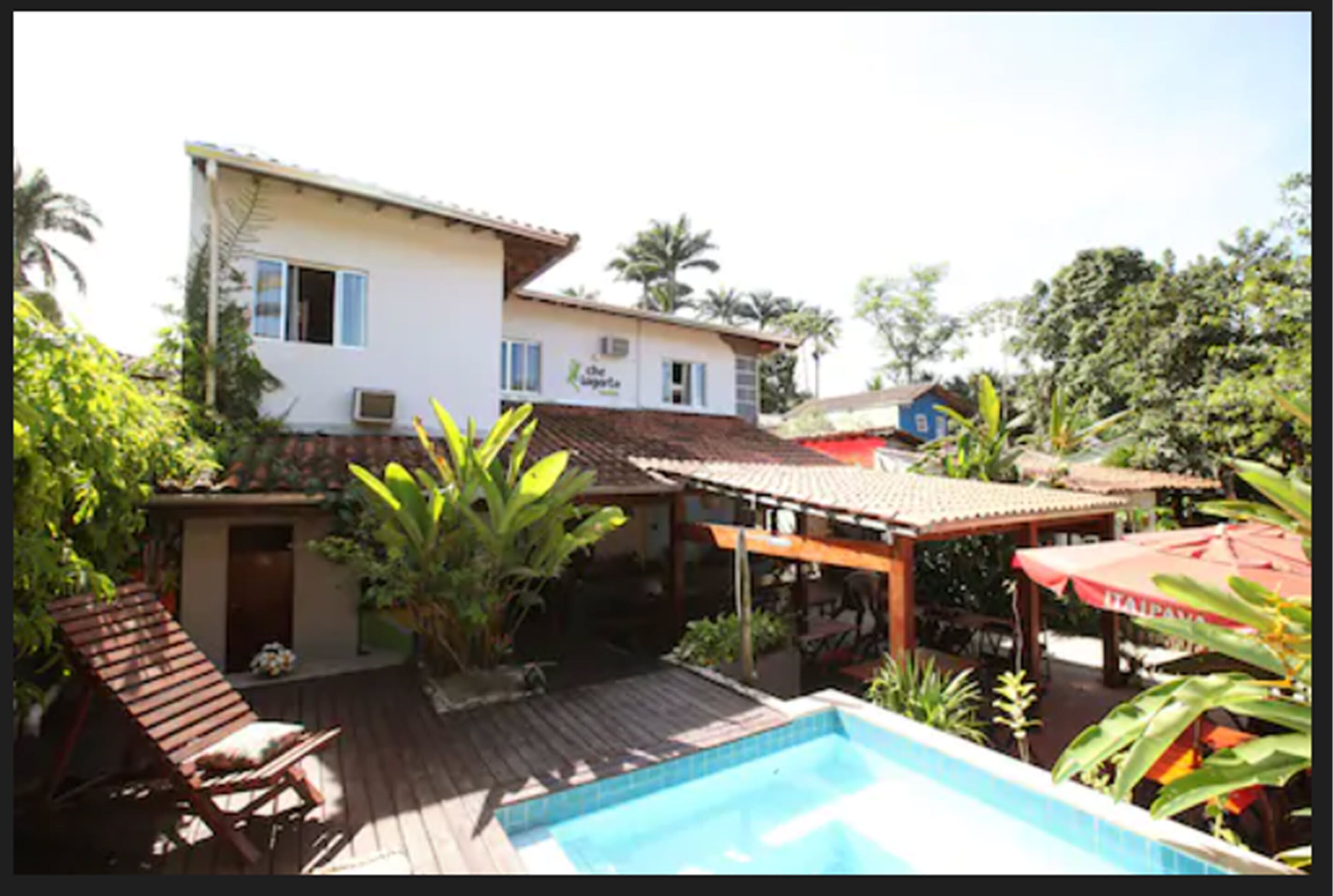 A house with a swimming pool, a patio area, and a covered outdoor seating area.