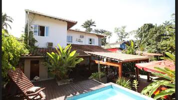 A house with a swimming pool, a patio area, and a covered outdoor seating area.