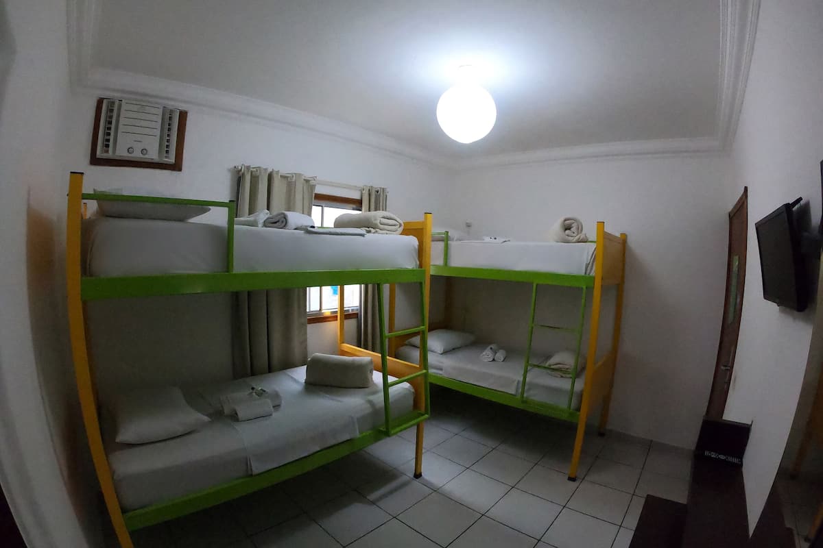 A bunk bed room with a ceiling fan, a window with curtains, and a wall-mounted thermostat.