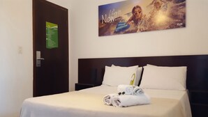 A hotel room with a neatly made bed, a wall-mounted sign, and a motivational poster. - Che Lagarto Paraty - Hostel (Paraty)