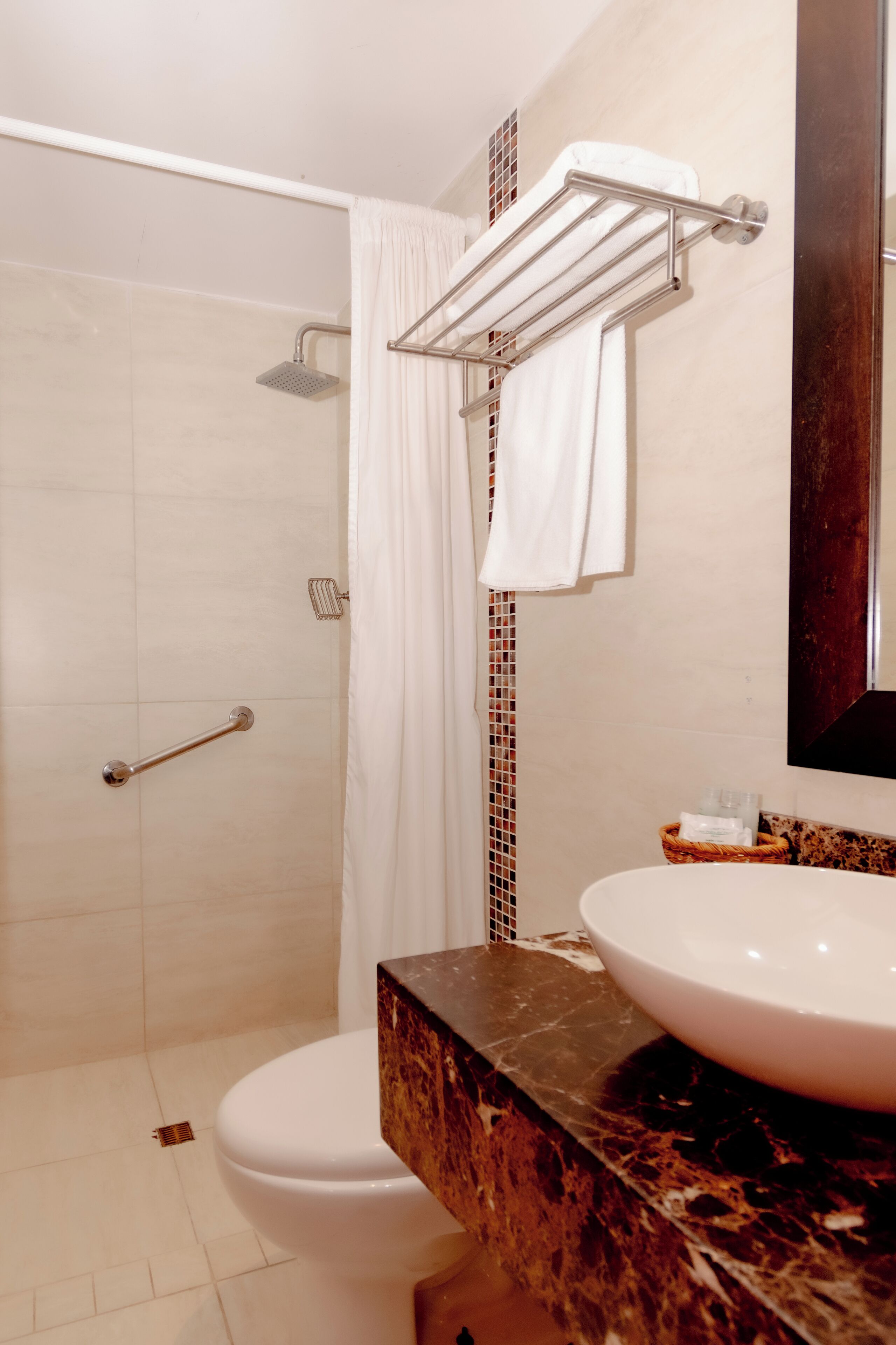 A bathroom with a shower, toilet, and sink.