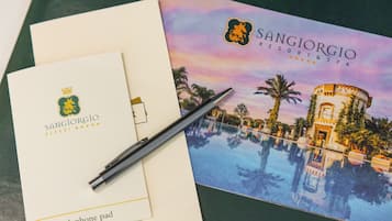 Un folleto del Sangiorgio Resort & Spa que muestra una vista de la piscina, un panel para el teléfono y un bolígrafo.