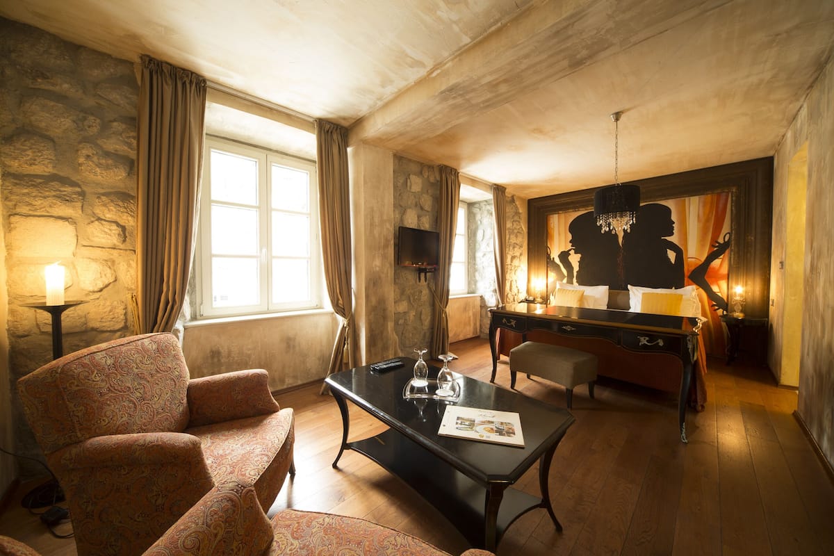 Une pièce confortable avec un canapé, une table, un bureau et un téléviseur.