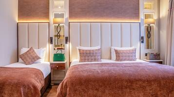Habitación de hotel con dos camas, una mesita de noche, un espejo y una lámpara.