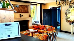 Una sala de estar acogedora con chimenea, un comedor y vistas al exterior.