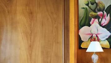 A wooden-paneled room with a painting of flowers, a table set with glasses and a lamp, and a sign reading "Domaine du Chatelier".
