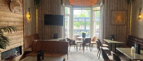 Un interior acogedor con una pared de madera, una lámpara de araña grande y un área de estar con un sofá y sillones.