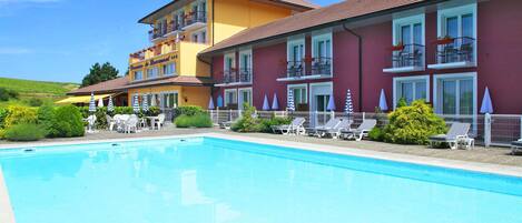 Een buitenzwembad en ligstoelen