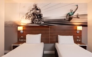 A hotel room with two beds, wooden headboards, and a large wall mural depicting a train and a person running. - Heeton Concept Hotel City Centre Liverpool (Liverpool)