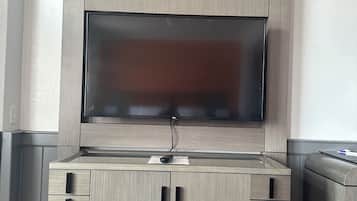 Un moble modern d'entreteniment amb un televisor de pantalla plana, diversos calaixos i un armari integrat.