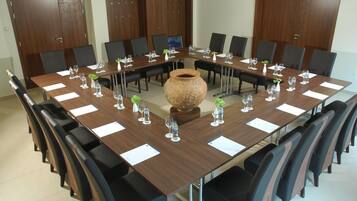 A conference room with a long table, chairs, and a large vase centerpiece.